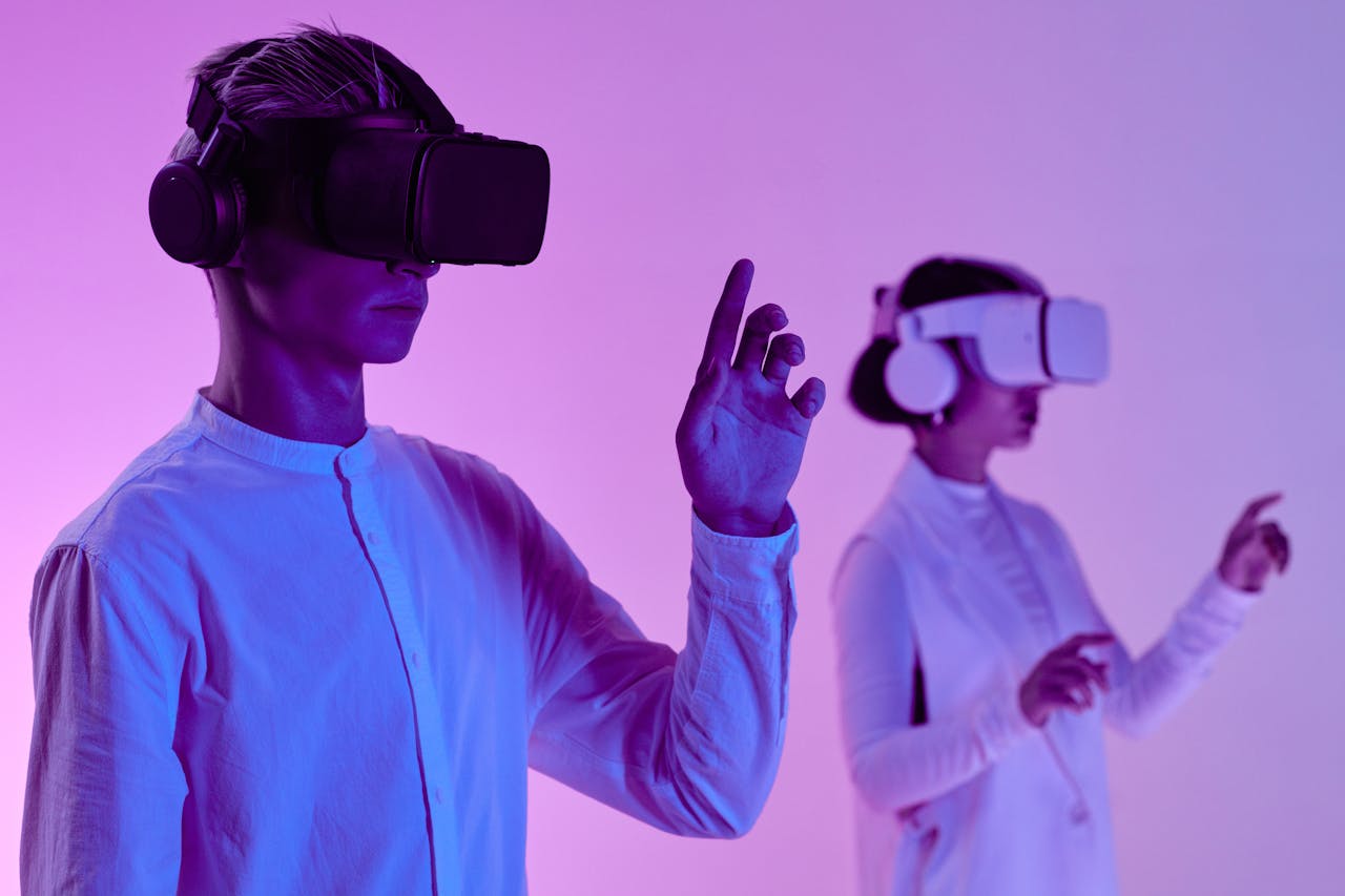 hero-img-01 Two people engage in a futuristic virtual reality simulation with headsets and vibrant lighting.